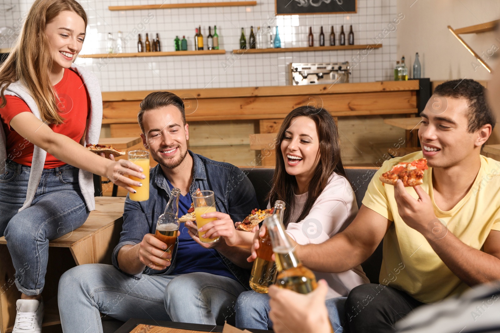 Photo of Group of friends having fun party with delicious pizza in cafe