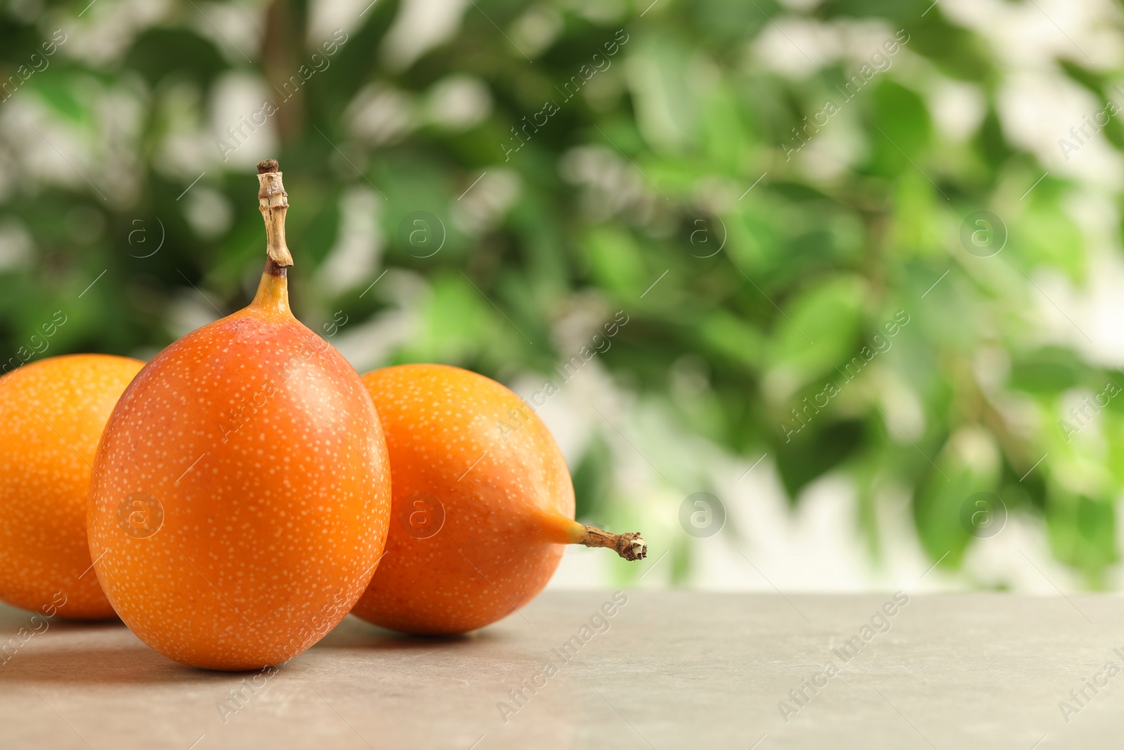 Photo of Delicious ripe granadillas on light grey table. Space for text