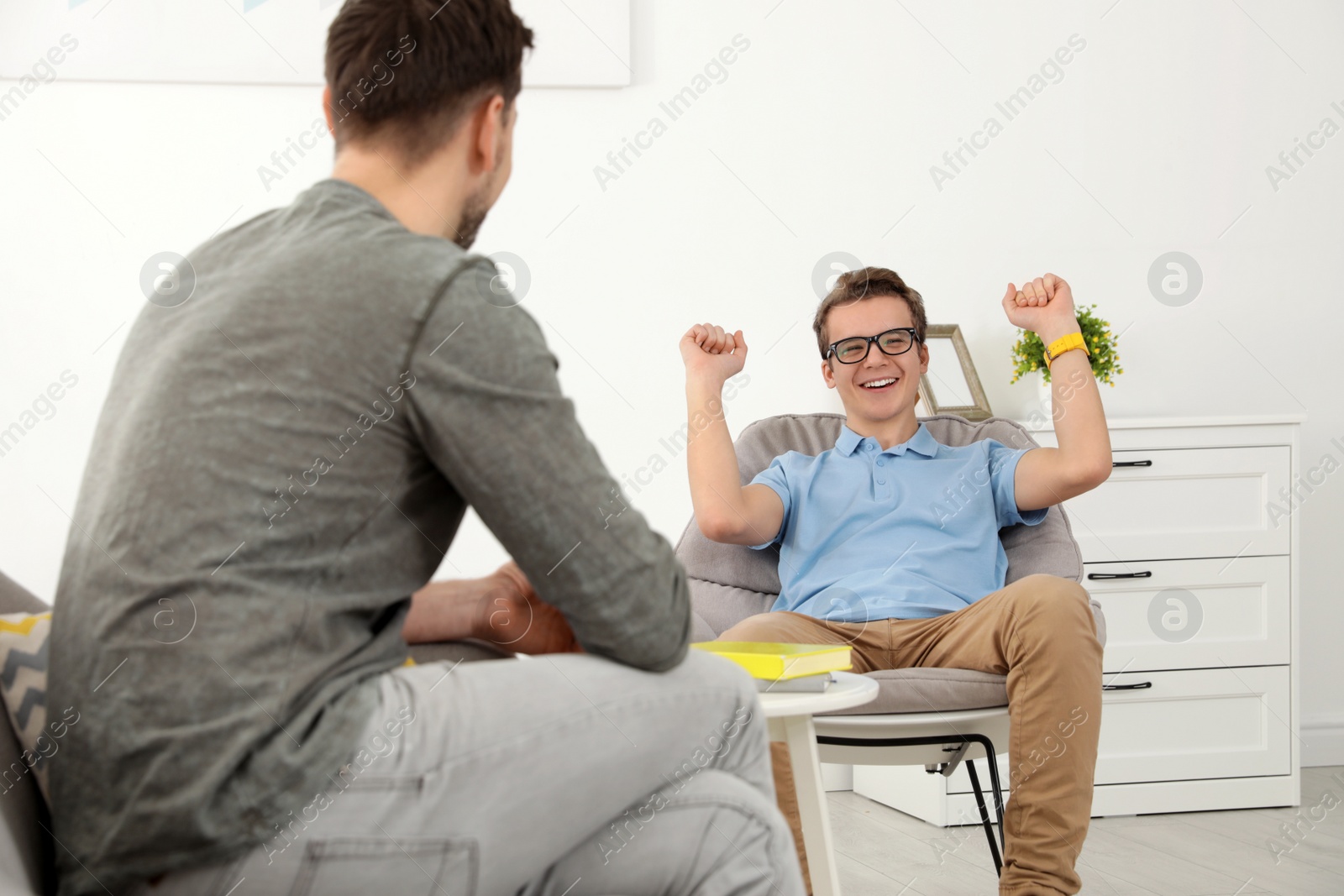 Photo of Father talking with his teenager son at home