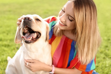 Photo of Cute yellow labrador retriever with owner outdoors