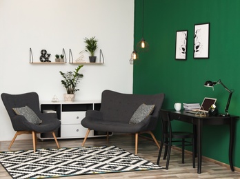 Photo of Modern living room interior with workplace near green wall