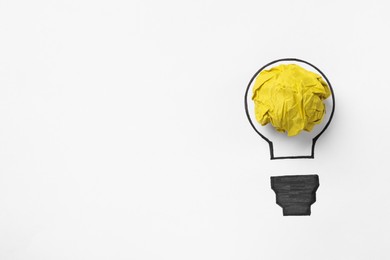 Photo of Idea concept. Light bulb made with crumpled paper and drawing on white background, top view. Space for text
