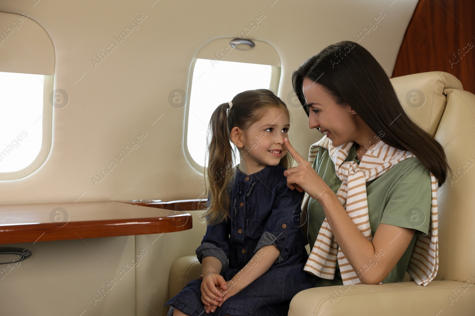 Photo of Mother and daughter in airplane during flight