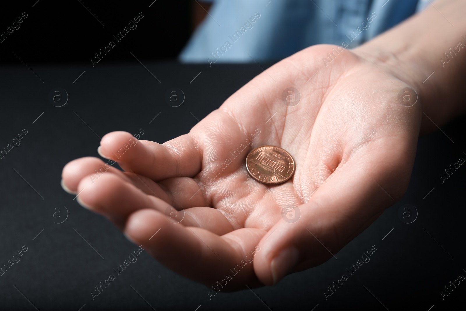 Photo of Young woman holding coins on black background, closeup view