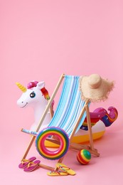 Deck chair, flip flops and other beach accessories on pink background. Summer vacation