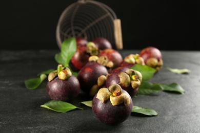 Photo of Fresh ripe mangosteen fruits on dark grey table