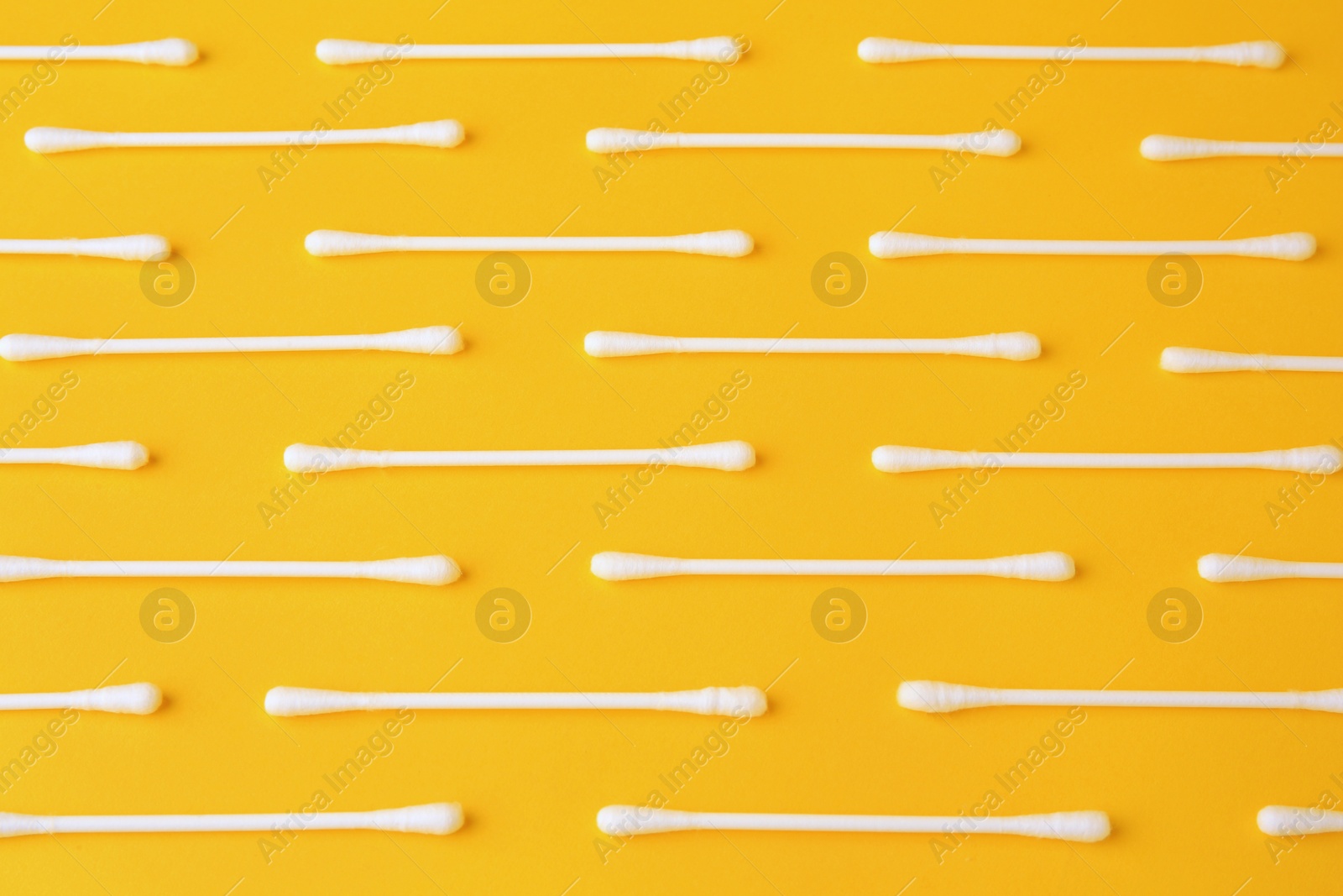 Photo of Many clean cotton buds on yellow background, flat lay