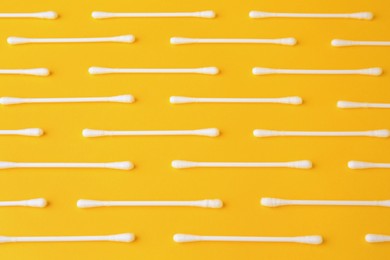 Photo of Many clean cotton buds on yellow background, flat lay