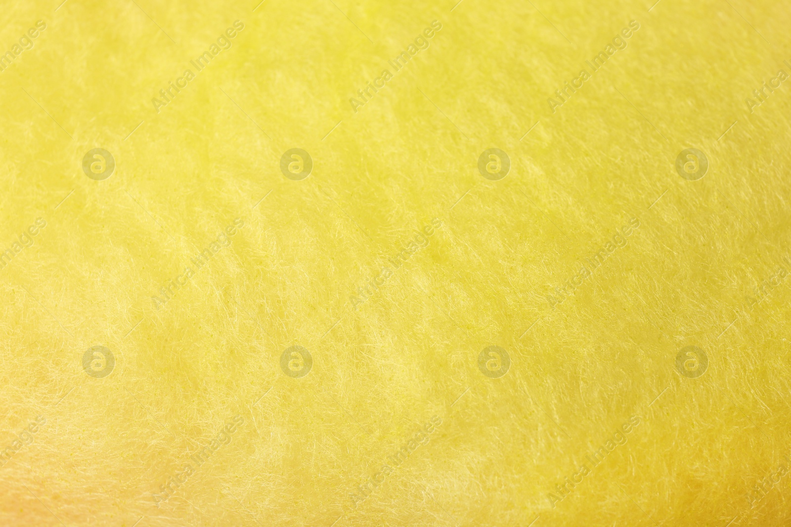 Photo of Sweet yellow cotton candy as background, closeup