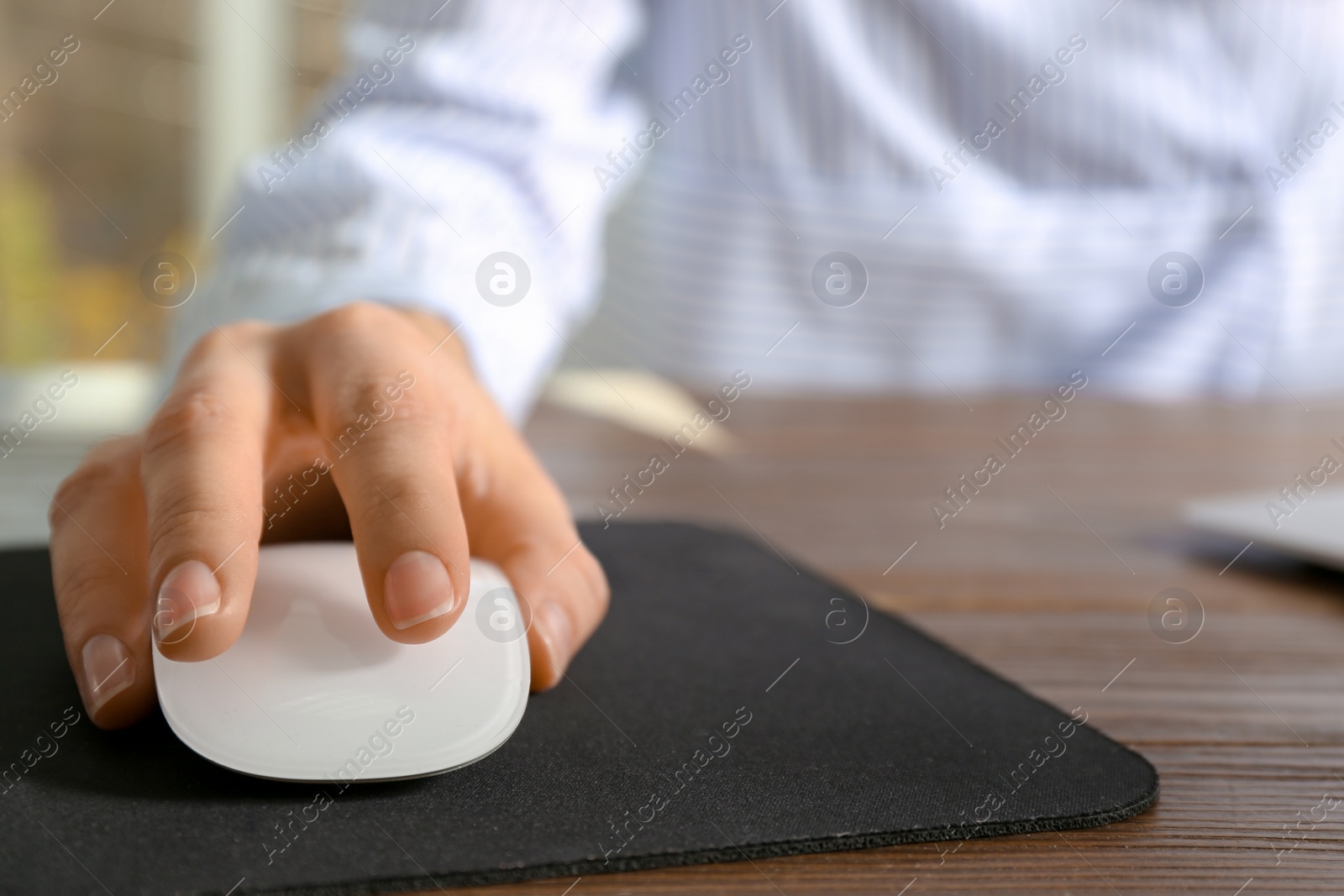 Photo of Woman using computer mouse at table, closeup