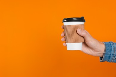 Photo of Woman holding takeaway cup with drink on orange background, closeup view and space for text. Coffee to go