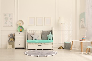 Photo of Cozy baby room interior with crib and toys