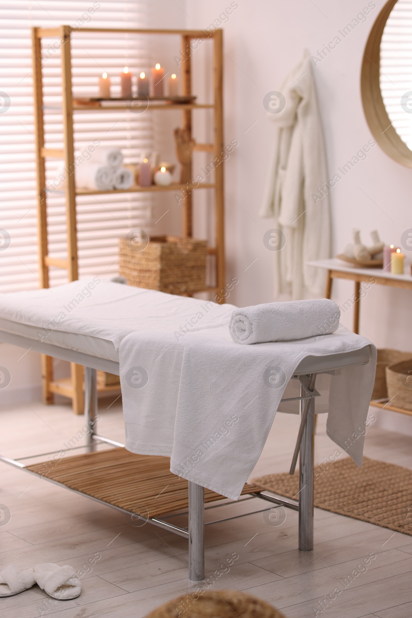 Photo of Comfortable massage table with clean towels in spa center