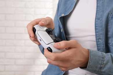 Photo of Man using wireless game controller indoors, closeup