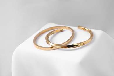 Photo of Stylish presentation of bracelets on white cloth, closeup