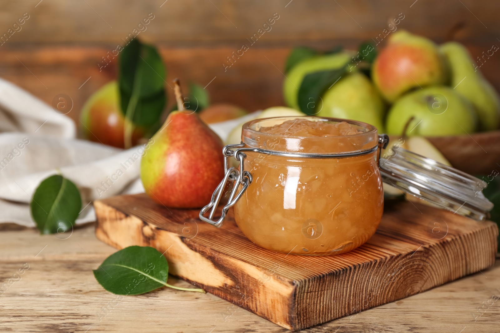 Photo of Delicious pear jam and fresh fruits on wooden table. Space for text