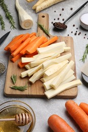 Composition with parsnips, carrots and other products on light grey table