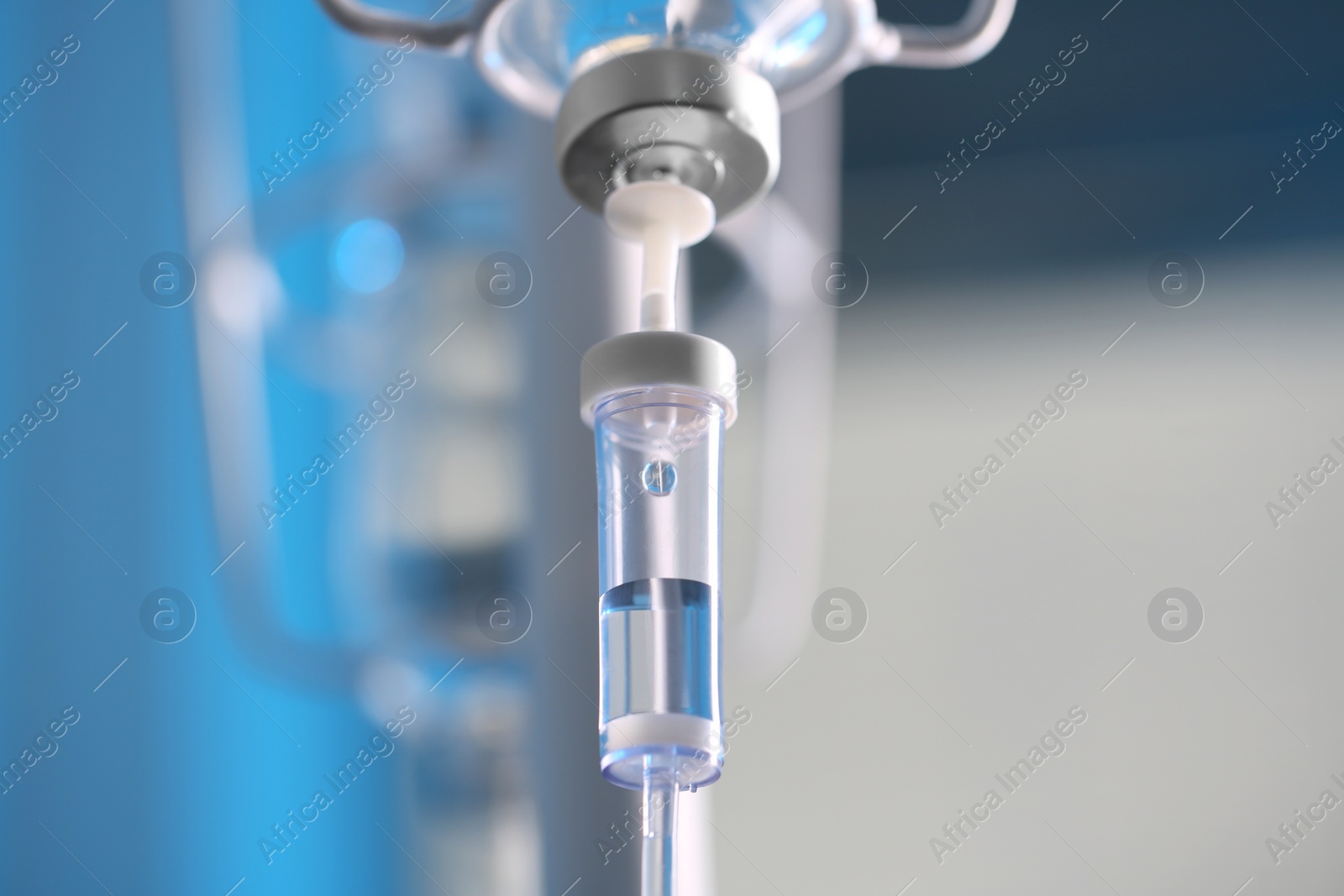 Photo of IV drip chamber against blurred light background