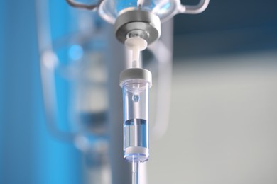 Photo of IV drip chamber against blurred light background