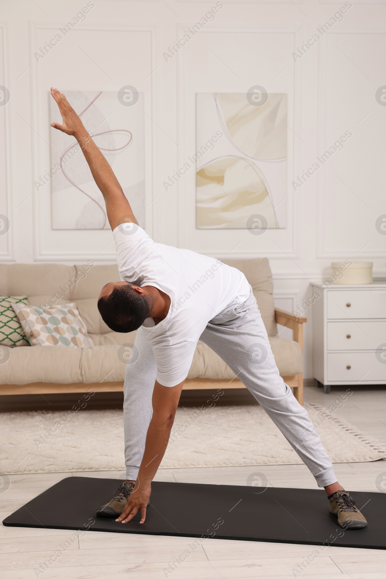 Photo of Man doing morning exercise on fitness mat at home