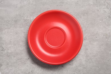 Photo of One red ceramic plate on light grey table, top view