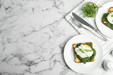 Delicious poached egg sandwich served on white marble table, flat lay. Space for text