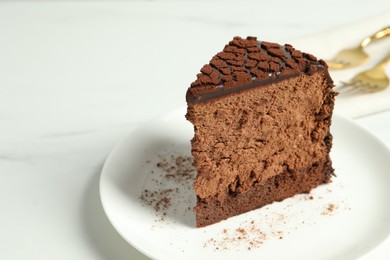 Photo of Piece of delicious chocolate truffle cake on white table, closeup