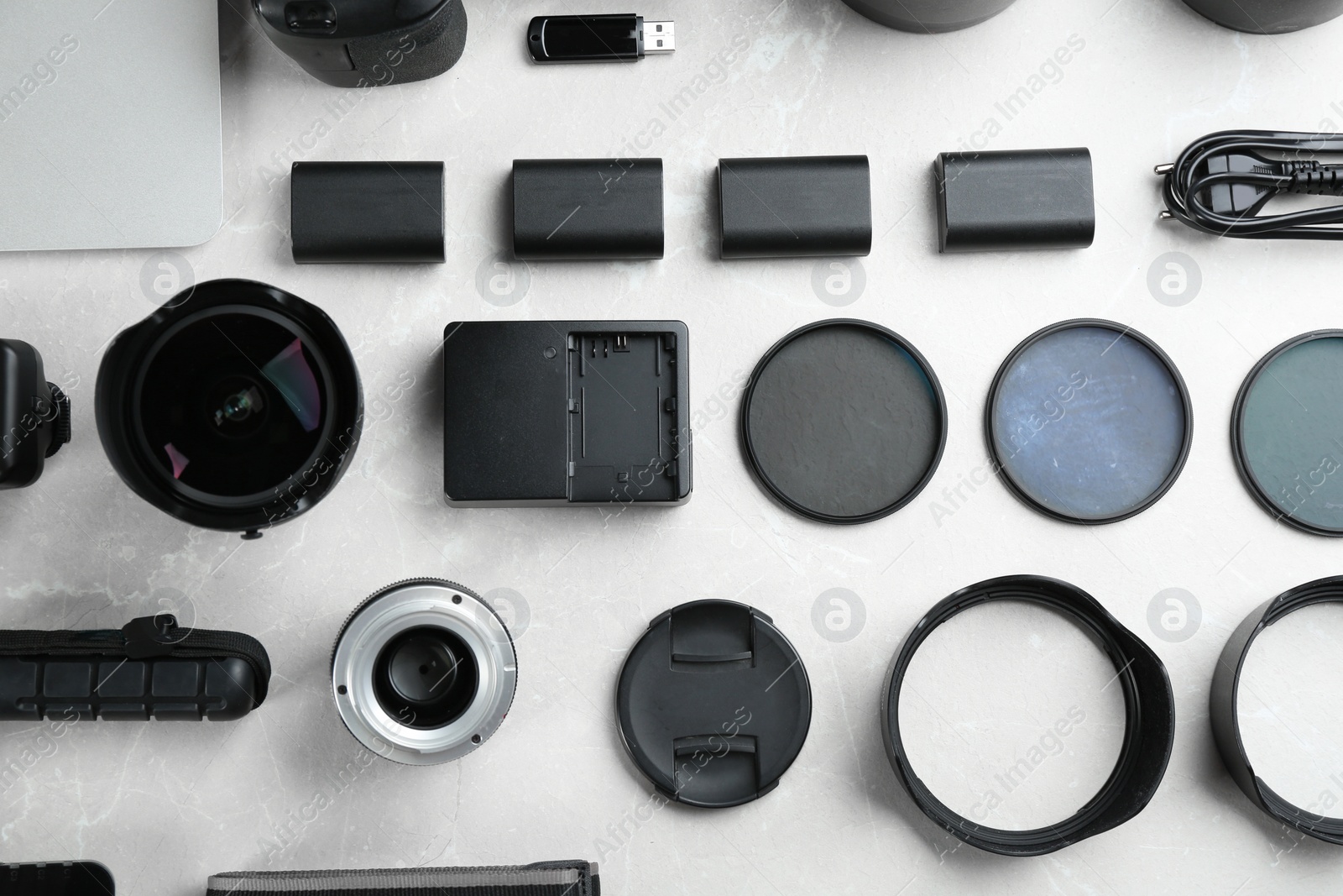 Photo of Flat lay composition with equipment for professional photographer on grey marble table