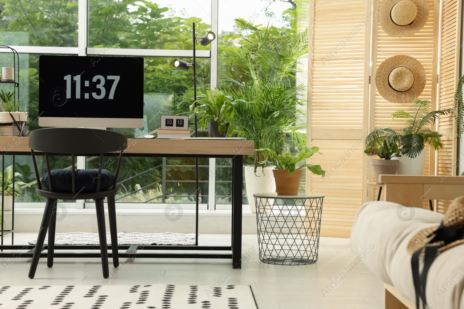 Photo of Comfortable workplace with computer in light room. Interior design