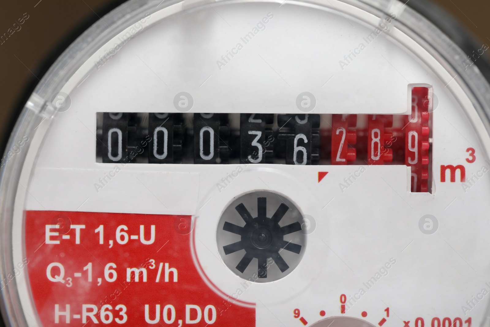 Photo of Electric meter on blurred background, closeup view. Water measuring device