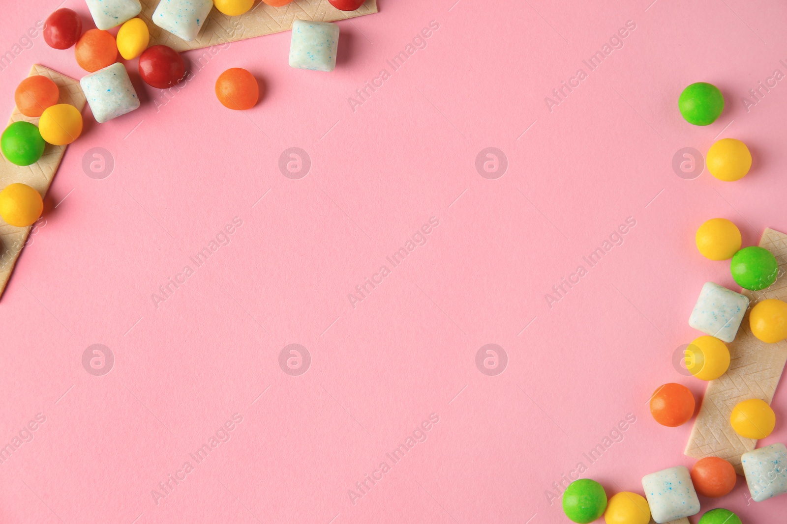 Photo of Different tasty chewing gums on pink background, flat lay. Space for text