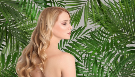 Image of Beautiful young woman and tropical leaves. Spa portrait