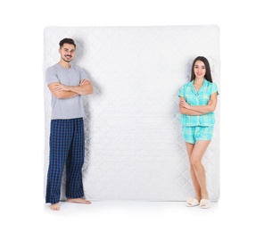 Young couple with comfortable mattress isolated on white