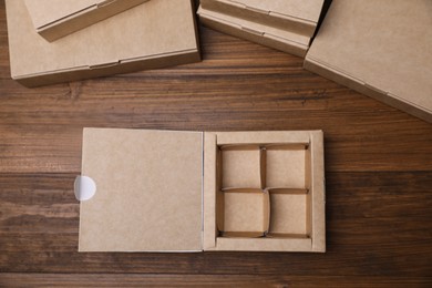 Photo of Open empty packaging box on wooden table, flat lay. Production line