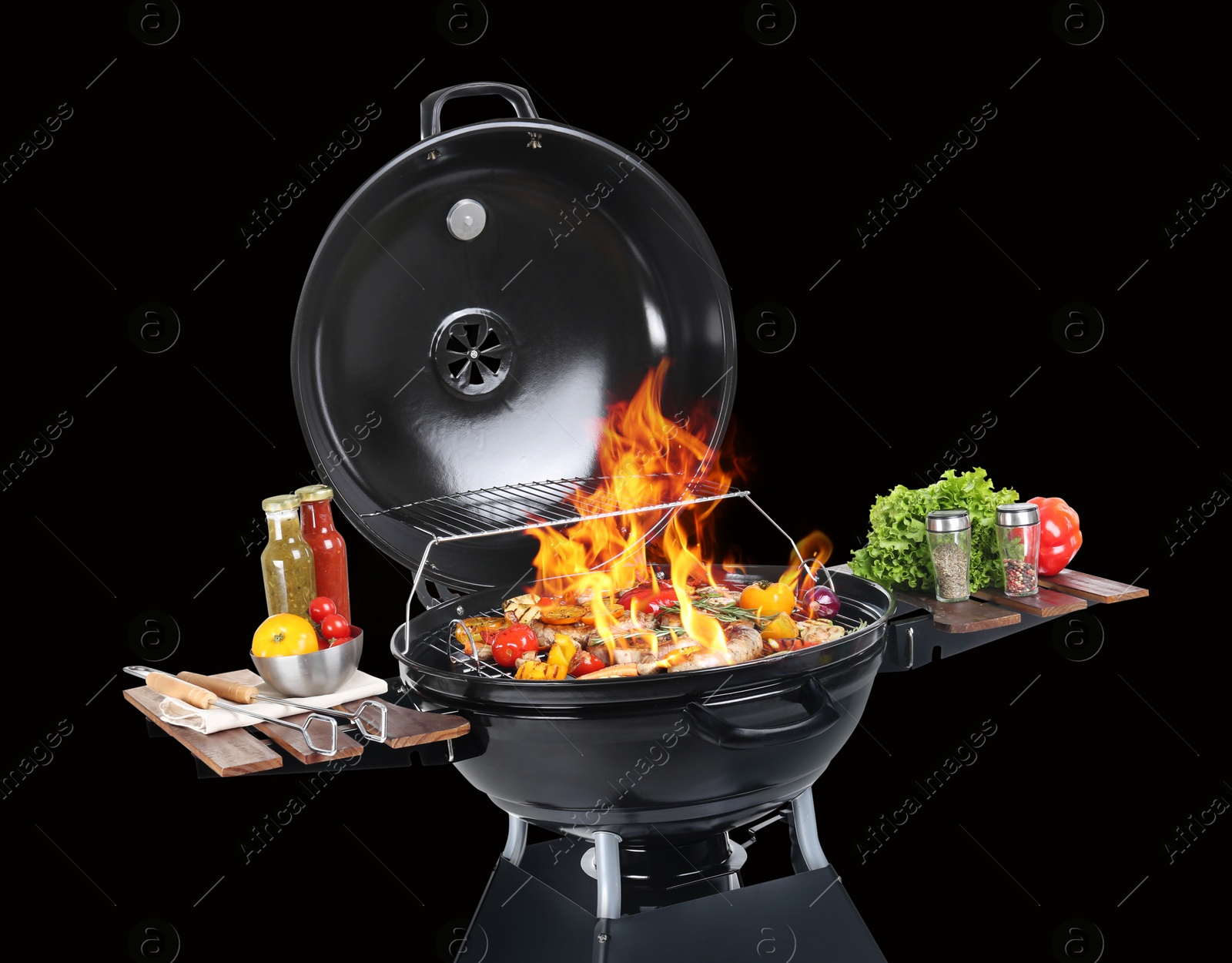 Image of Modern flaming barbecue grill with tasty food on black background