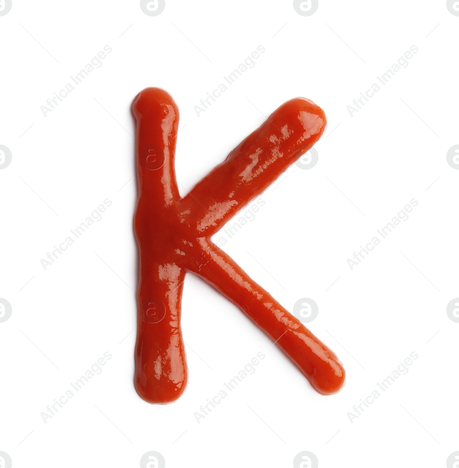 Photo of Letter K written with ketchup on white background