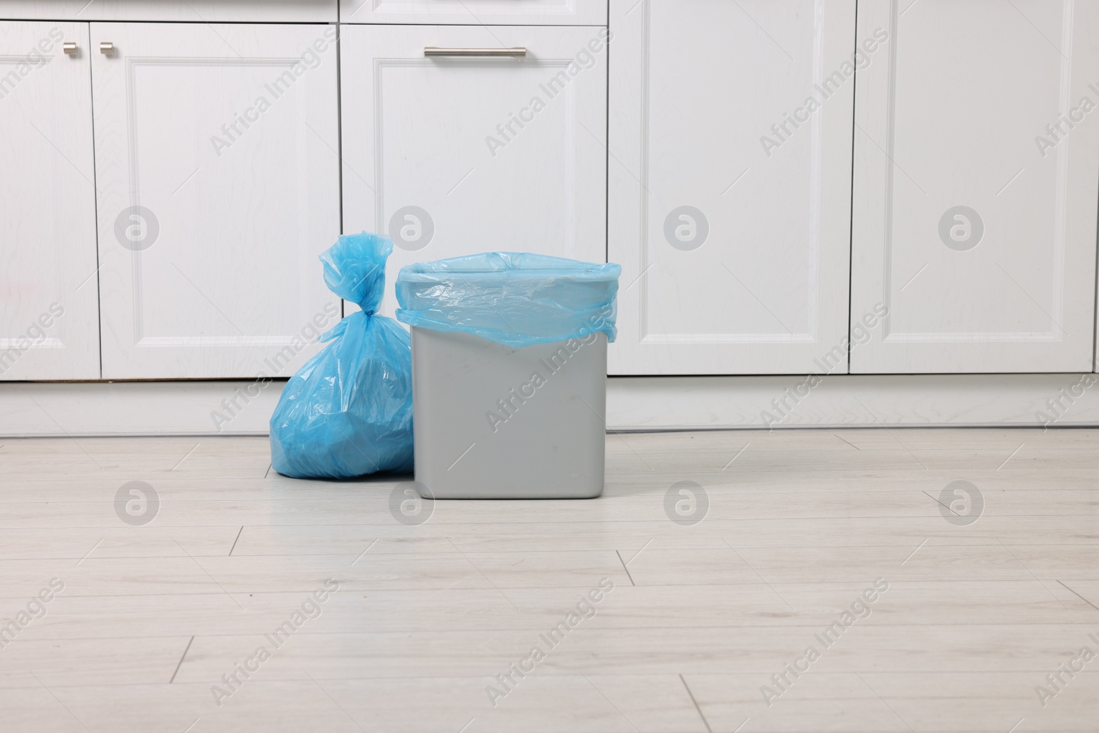 Photo of Plastic garbage bag and trash can in kitchen