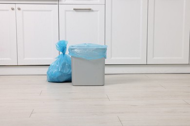 Photo of Plastic garbage bag and trash can in kitchen