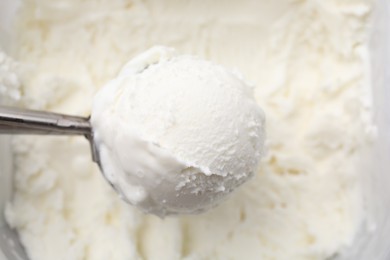 Steel scoop with tasty vanilla ice cream, top view