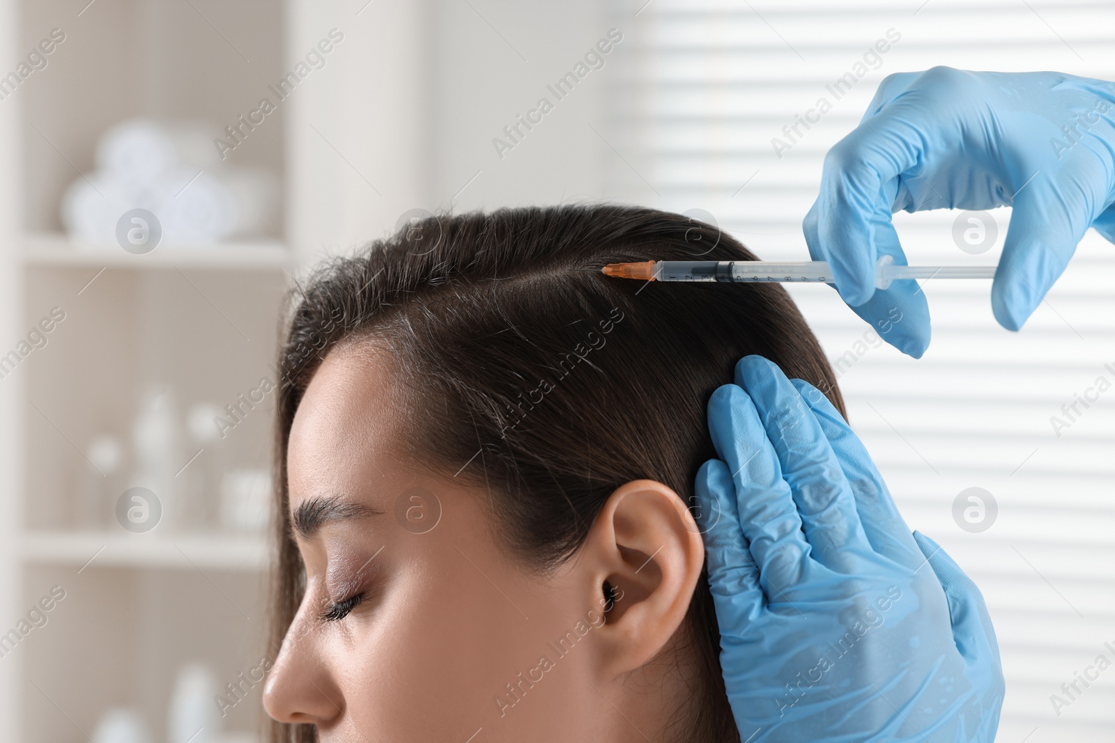 Photo of Trichologist giving injection to patient in clinic, closeup