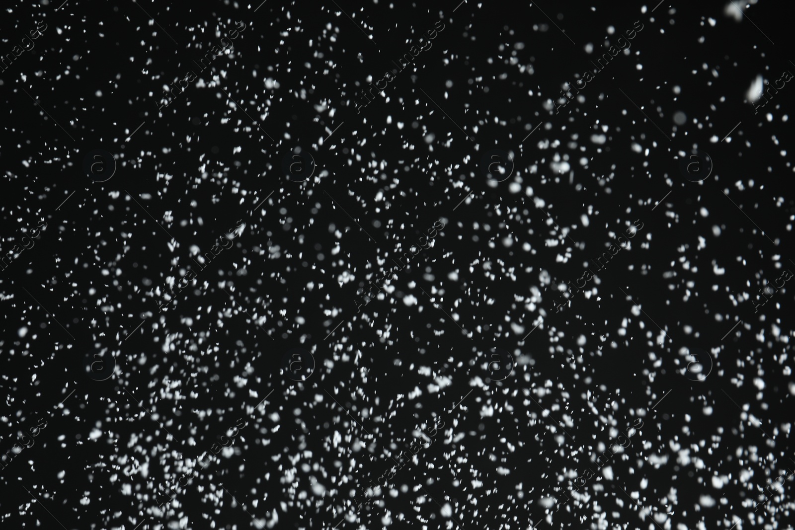 Photo of White snow falling down on black background