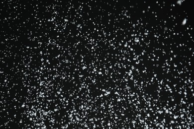 White snow falling down on black background