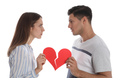 Photo of Couple with torn paper heart on white background. Relationship problems