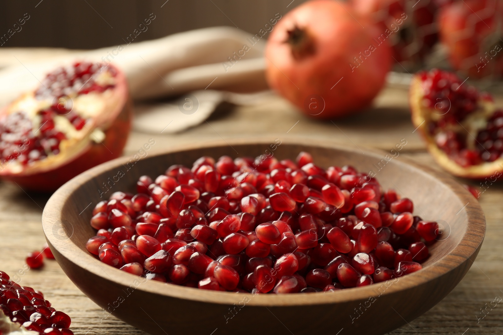 Photo of Ripe juicy pomegranate grains in bowl on table, closeup