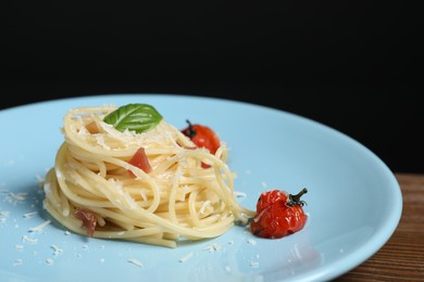 Photo of Tasty spaghetti with tomatoes and cheese on wooden table, closeup. Exquisite presentation of pasta dish