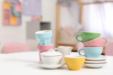 Toy dishware on small table in child's room, closeup