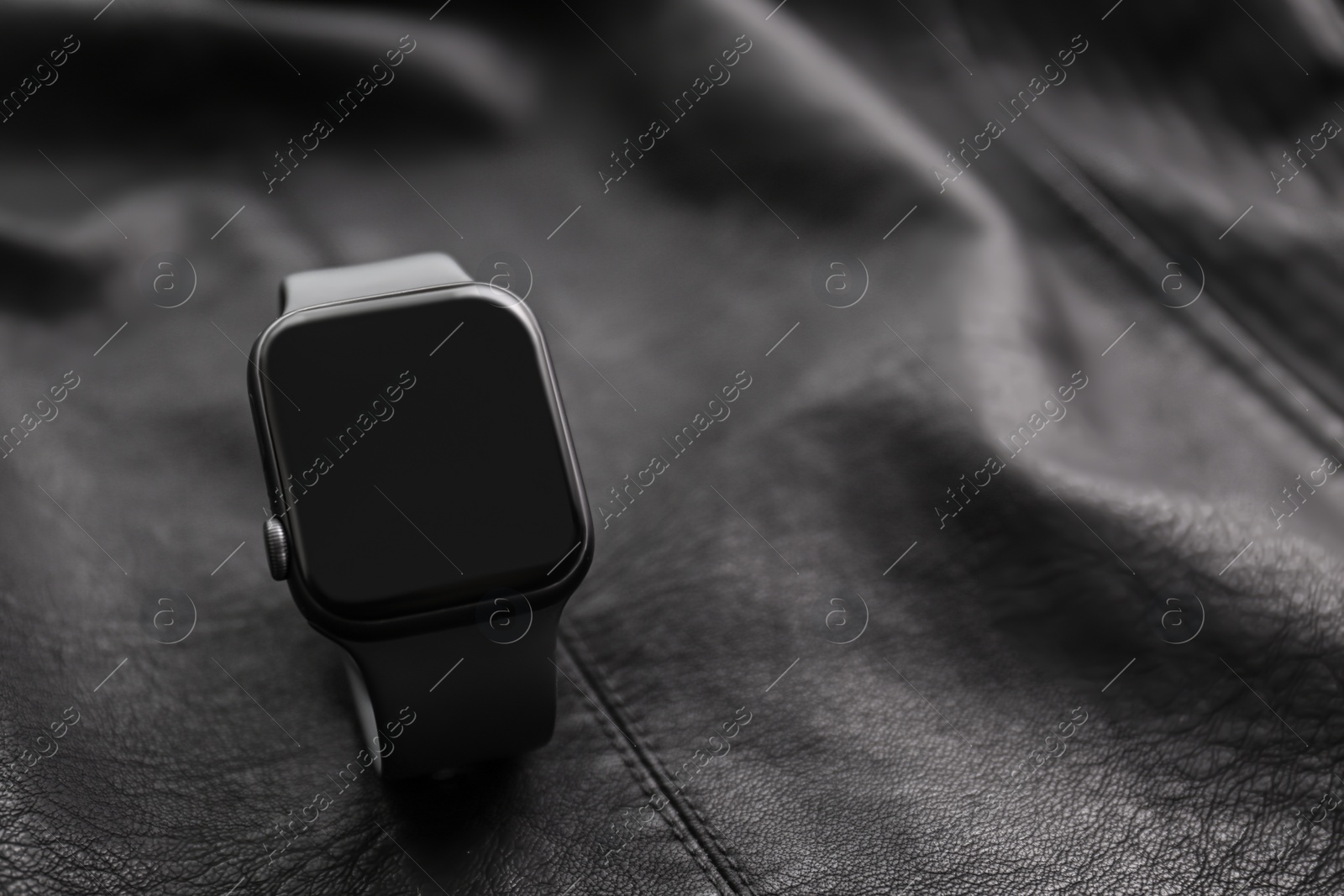 Stylish smart watch on black leather fabric, closeup. Space for text Photo of Stylish smart watch on black leather fabric, closeup. Space for text