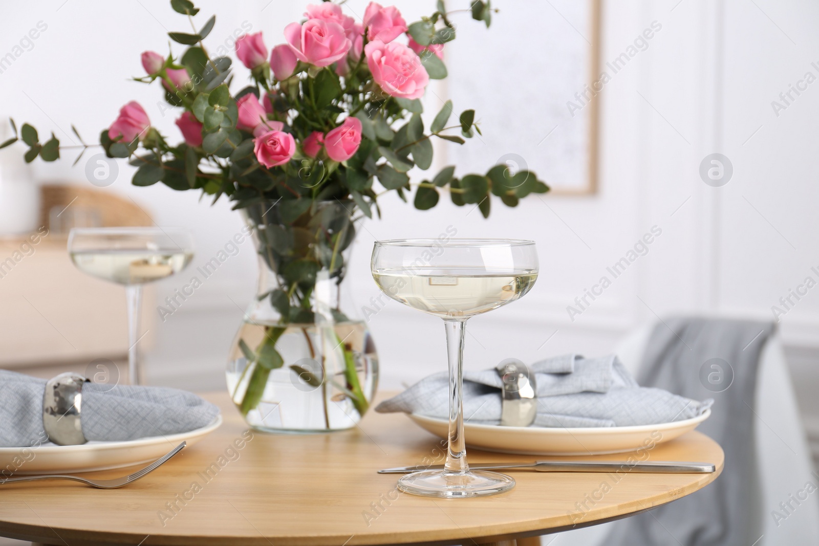 Photo of Place setting with pink roses on wooden table. Romantic dinner