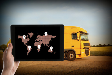 Image of Logistics concept. Man using tablet with world map on screen against truck
