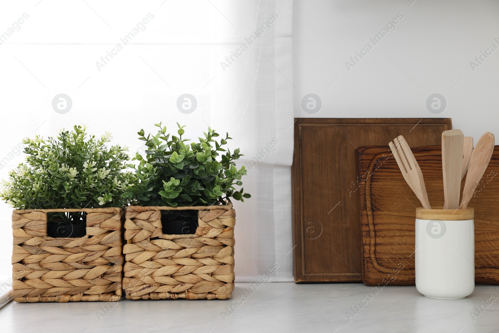 Photo of Different potted artificial plants on countertop in kitchen. Home decor